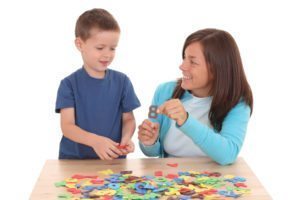 preschooler and mother playing with letters isolated on white